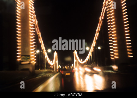 Attraversando il Chelsea Bridge da Battesea durante la notte con le luci offuscata dalla presa a velocità Londra UK Marzo 1998 Foto Stock