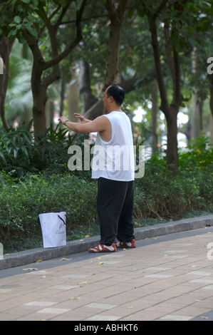 Cinese pratiche shopper Tai Chi in Victoria Park Hong Kong Foto Stock