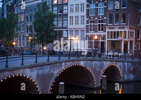 Vista su ponte illuminato di case a capanna in serata Keizersgracht e Leidsegracht Amsterdam Olanda Paesi Bassi Foto Stock