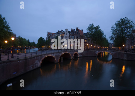 Vista su ponte illuminato di case a capanna in serata Keizersgracht e Leidsegracht Amsterdam Olanda Paesi Bassi Foto Stock