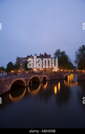 Vista su ponte illuminato di case a capanna in serata Keizersgracht e Leidsegracht Amsterdam Olanda Paesi Bassi Foto Stock