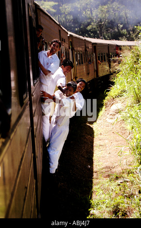 La scuola dei bambini appoggiata al di fuori di un treno in movimento - Sri Lanka Foto Stock