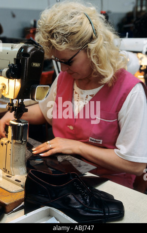La Serbia, Jugoslavia. Fabbrica di scarpe; donna lavora su una macchina. Foto Stock