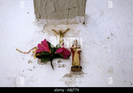 Sao Paulo, Brasile. Tipico display religiosa su una parete bianca (croce, Gesù, fiori). Foto Stock