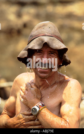 Lukulu, Zambia. Uomo sorridente in wet martoriata bush hat con acqua che gocciola sul suo viso e corpo; David Maskell. Foto Stock