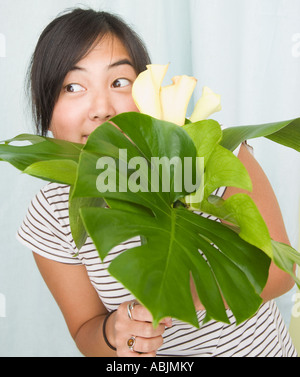 Donna spiata su foglie e fiori Foto Stock