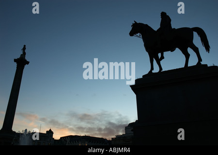 Statua di Re Giorgio IV a cavallo e Nelson's colonna in silhouette, Trafalgar Square London REGNO UNITO Foto Stock