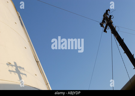 Palo del telegrafo silhouette e ombra contro il cielo blu e del serbatoio di accumulo al Kerry Bio-Science lievito della fabbrica a Leicester. Foto Stock