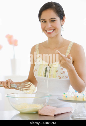 Donna pastella di agitazione in cucina Foto Stock