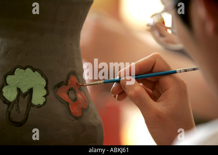 Artista giovane ragazzo ansimando decorate in ceramica spazzola fatto a mano in terracotta argilla arte gettato ciotola vaso in ceramica porcellana cina Foto Stock