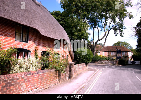 Cottage con il tetto di paglia con Millstream Hotel in background vecchio Bosham nelle vicinanze del Chichester West Sussex Regno Unito Foto Stock