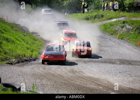 Vetture in Folkrace banger racing velocità attraverso la campagna alzando nuvole di polvere a Torslanda Racecourse a Göteborg in Svezia Foto Stock