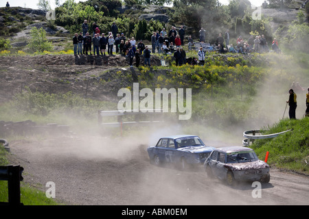 L'aumento di nubi di polvere Folkrace banger racing cars curva attraverso la campagna a Torslanda Racecourse a Göteborg in Svezia Foto Stock