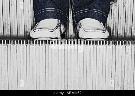 Donna che indossa jeans blu in piedi sulle scale di Escalator Foto Stock