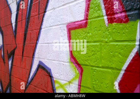 Graffiti spruzzato su un muro di mattoni in prospettiva laterale Foto Stock