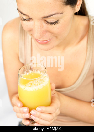 Giovane donna di bere succo di ananas Modello rilasciato Foto Stock