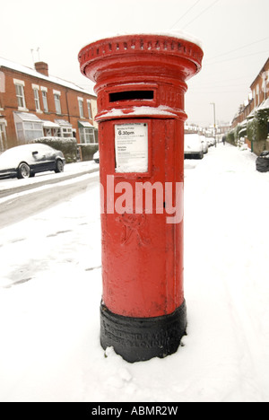 Un rosso british post box circondata da neve in Birmingham Foto Stock