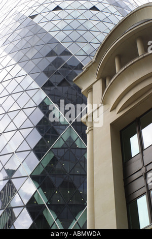 Contrasto di Londra architettura stile moderno edificio Gherkin al fianco di edificio di stile contemporaneo Foto Stock