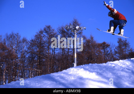 Snowboarder vola attraverso l'aria di Hokkaido in Giappone Foto Stock