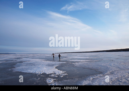 Persone il pattinaggio sul lago ghiacciato Foto Stock