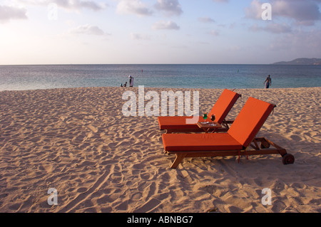 Due caratteri vuoti con bevande sulla spiaggia di sabbia dorata nel tardo pomeriggio Grand Anse Beach Grenada Caraibi Foto Stock