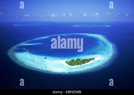 Isola tropicale nel nord est atollo di Ari con cinta reef nelle Maldive circondato da aqua acque blu dell'Oceano Indiano Foto Stock