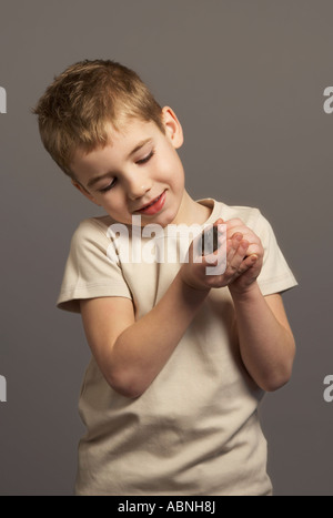 Little Boy Holding Hamster Foto Stock