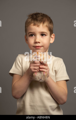 Little Boy Holding Hamster Foto Stock