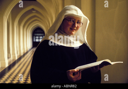 Una giovane suora cattolica legge istruzione religiosa a Standbrook Convento Abbey Regno Unito Foto Stock