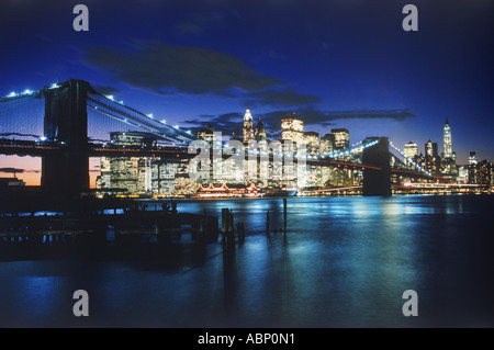 Ponte di Brooklyn su East River con New York skyline della città di notte Foto Stock