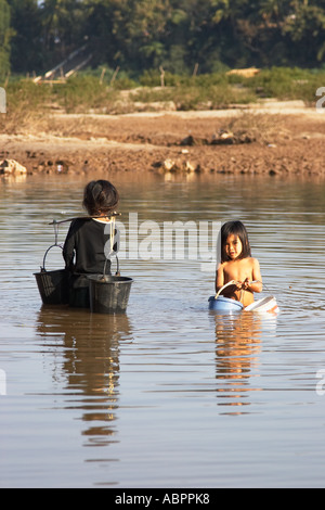 Le ragazze di raccogliere l'acqua dal fiume Mekong Foto Stock