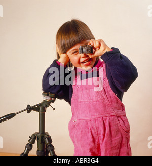 Giovane ragazza appoggiata sul treppiede e guardando attraverso mini telecamera. Foto di Willy Matheisl Foto Stock