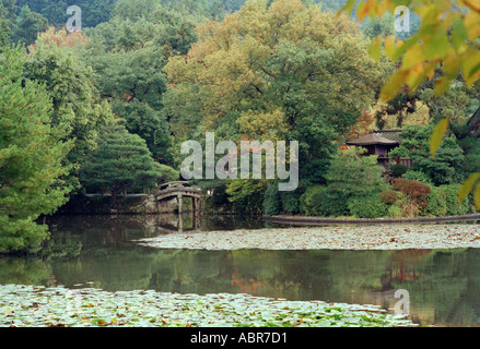 Alberi rigogliosi, ninfee, teahouse, bridge e riflessi nel Kyoyo chi Pond nei Giardini del Tempio di Ryoanji, Kyoto, Giappone Foto Stock