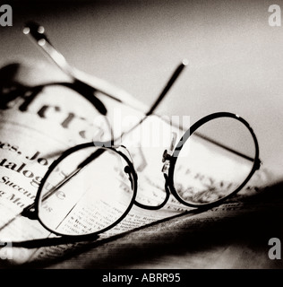 Gli occhiali da lettura giacente sul giornale Foto Stock