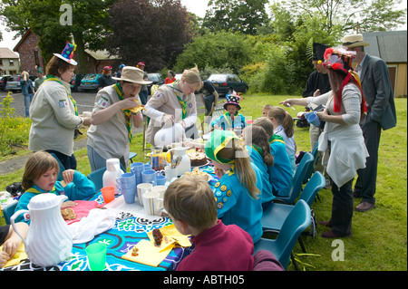 Gli scout e lupetti godendo un Mad Hatters tea party in corrispondenza di un evento di campagna Foto Stock