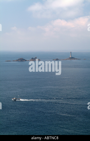 Barca da pesca passa Longships Lighthouse vicino al Lands End Cornwall Inghilterra Regno Unito Regno Unito Foto Stock