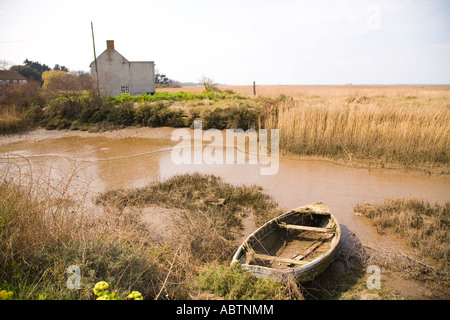 Paesaggio in North Norfolk che mostra un vecchio abbandonati in barca e cottage bianco Foto Stock