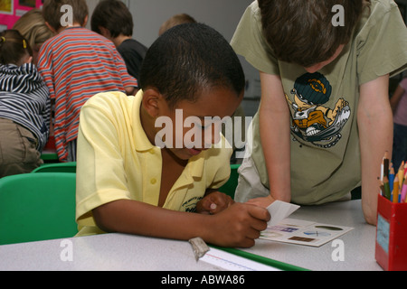 Due ragazzi di lavorare con un gioco di matematica in classe, Betty Layward junior school di Londra, Regno Unito. Foto Stock