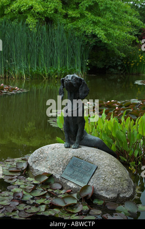 Figura in bronzo di bestia fantastico mezzo cane, metà pesce su una roccia in uno stagno Foto Stock