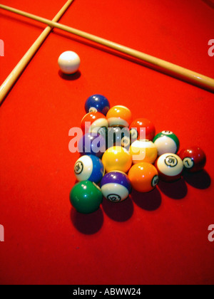 Oppresso Up Pool palle da biliardo in una forma triangolare e stecche da biliardo bastoni su un rosso Tavolo da biliardo visto dal di sopra Foto Stock