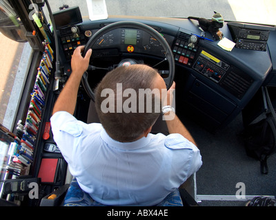 Birdseye vista del tour bus autista guida bus con oggetti personali nel vano del driver inclusi la raccolta della penna e mascotte Foto Stock