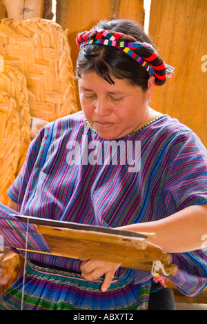 Donna al telaio per la tessitura artwork a mano di tessuti in un colorato dressin San Antonio sul telecomando lago Atitlan in Guatemala Foto Stock
