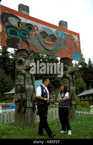 Totem Poles e Tlingit indiani nel Tlingit villaggio indiano di Alaska AK Foto Stock