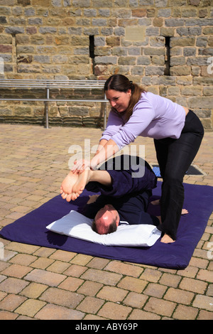 Stretching di entrambe le gambe come parte di un Thai massaggio corpo Foto Stock