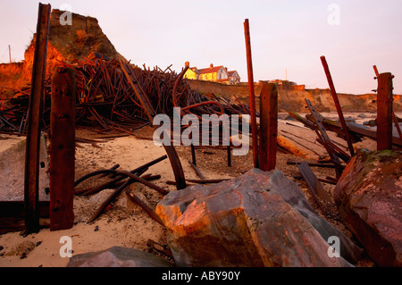 I resti del danneggiato mare difese a Happisburgh sulla costa di Norfolk Foto Stock