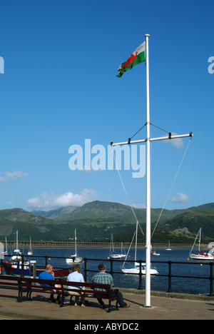 Blaenau Ffestiniog sedile con i vacanzieri e vedute del porto e cader Idris mountain range al di là di bandiera Gallese Foto Stock