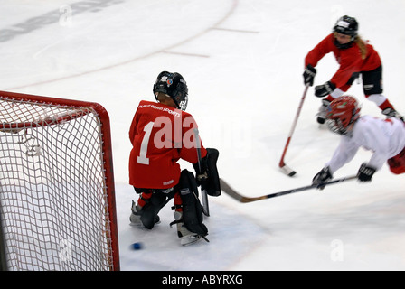 6 anno vecchio ragazzo riproduce la posizione del portiere in un teenager hockey su ghiaccio programma Foto Stock