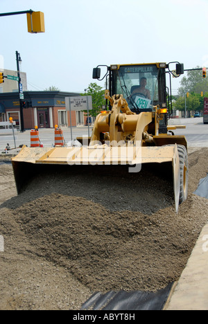 Grande escavatore industriale back hoe strada facendo i macchinari e le attrezzature viene utilizzato per effettuare una nuova strada asfaltata Foto Stock