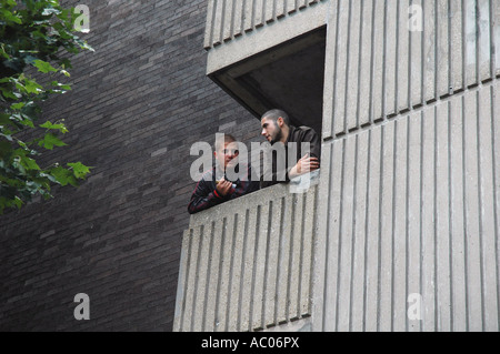 Due giovani chat sul balcone del grattacielo appartamento a Londra. Foto Stock