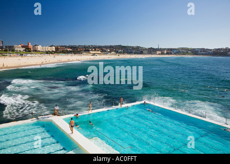 Nuotatori fare giri a scenic Bondi bagni sono riempiti oceano piscine costruite sul rockwalls all'estremità settentrionale Foto Stock